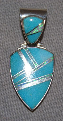 ZUNI STERLING PENDANT: 1990s sterling Silver with inlaid stone by James Rex, 2" long Shipping charge are for the United States. The shipping on this lot is $10.00. Outside the United States there will be additional shipping
