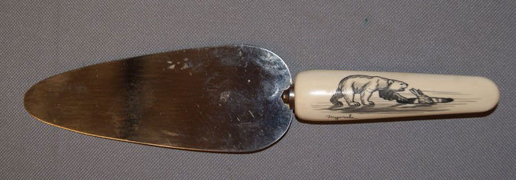 ESKIMO CAKE KNIFE: 1970s with ivory handle scrimshaw polar bear scene signed but unreadable 9" x 2" Shipping charge are for the United States. The shipping on this lot is $10.00. Outside the United States there will be
