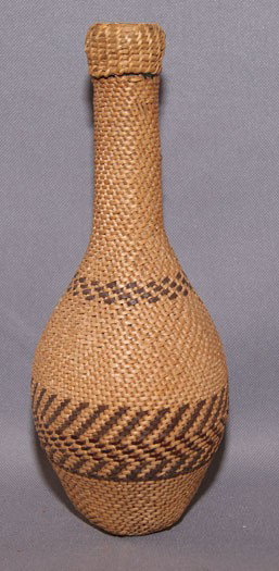 PAIUTE BASKETRY BOTTLE: 1930s concentric band design woven over wine bottle, 9.5" tall Shipping charge are for the United States. The shipping on this lot is $20.00. Outside the United States there will be additional shippin
