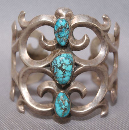 NAVAJO BRACELET: 1960s 70s sterling Silver and three turquoise stones sand Cast style signed with logo 2.5" x 5.25" 1 inch opening Shipping charge are for the United States. The shipping on this lot is $10.00. Outside