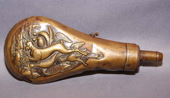 WESTERN POWDER FLASK: 1900s brass with embossed game scene one side dented one strap hook missing 8" x 3" Shipping charge are for the United States. The shipping on this lot is $10.00. Outside the United States there will 