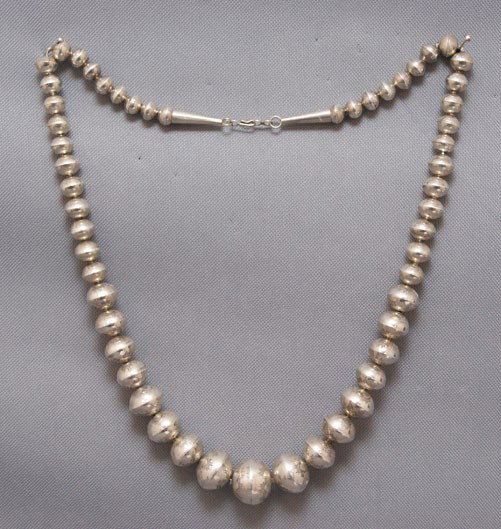 Navajo necklace: 1980s 90s sterling silver hand stamp design with graduated beads, 26" long beads 1/4" - 3/4" Shipping charge are for the United States. The shipping on this lot is $10.00. Outside the United States th