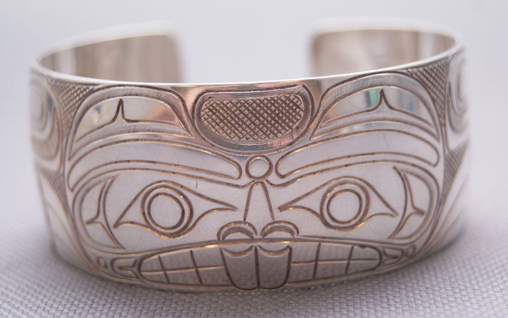 NORTHWEST COAST BRACELET: contemporary sterling silver with beaver face design signed TJH, 5.5" x 1" x 1" Shipping charge are for the United States. The shipping on this lot is $10.00. Outside the United States there will be a