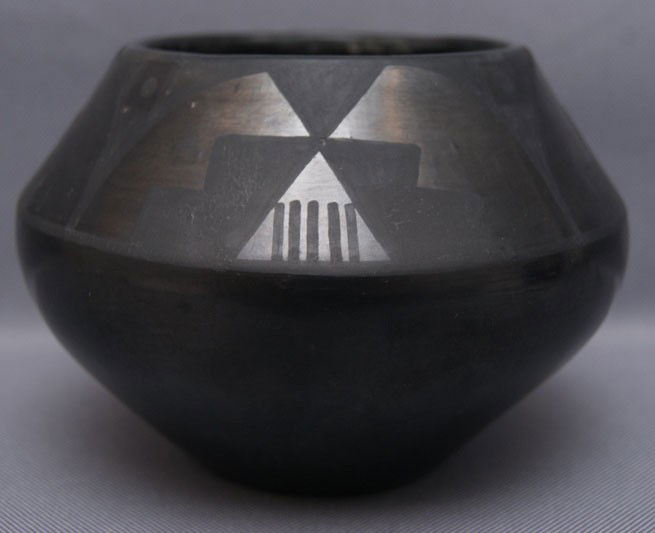 SAN ILDEFONSO POTTERY JAR: 1950s-60s matte on black with minor surface scratches and rubs, signed Anna, 4"x4.75" The shipping on this lot is $10.00.