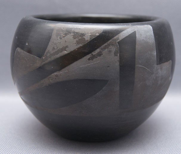 SAN ILDEFONSO POTTERY BOWL: 1960s 70s matte on black with minor pitting and scratchs, 3.75" x 4.5" The shipping on this lot is $10.00.