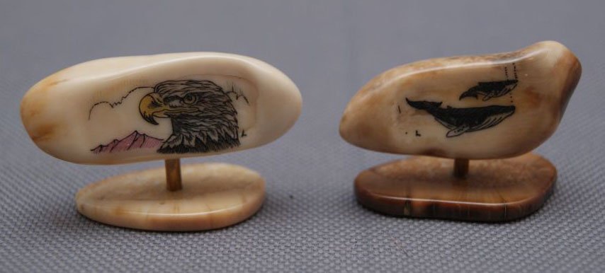 TWO FOSSILIZED IVORY TEETH: 1960s with scrimshaw whale and Eagle design mounted on stands, 1" x 1.5" Shipping charge are for the United States. The shipping on this lot is $10.00. Outside the United States there will be addition