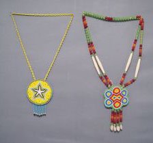 TWO PLAINS NECKLACES: 1970s 80s beaded rosettes, small one 3.5" diameter and 24" long, large one 3.75" diameter and 26" long Shipping charge are for the United States. The shipping on this lot is $10.00. Outside the United