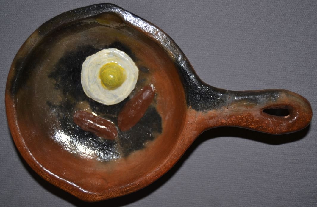 NAVAJO POTTERY FRYING PAN: contemporary glaze ware painted sausage and eggs handle has been broken and glued signed BM for Betty Manygoats 1.25"x9"x6" Shipping charge are for the continental United States only There will be add