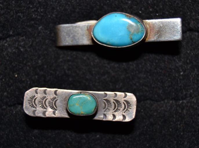 TWO NAVAJO TIE CLIPS: 1960s 70s sterling silver fronts one has stamped design and single turquoise stones approx. .25"x1" Shipping charge are for the continental United States only There will be additional shipping fees on