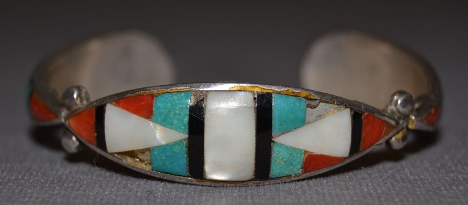 NAVAJO SILVER BRACELET: 1960s 70s sterling silver stone to stone inlay turquoise coral jet and mother of pearl missing 2 stones 5"x.5"x1" Shipping charge are for the continental United States only There will be additional sh