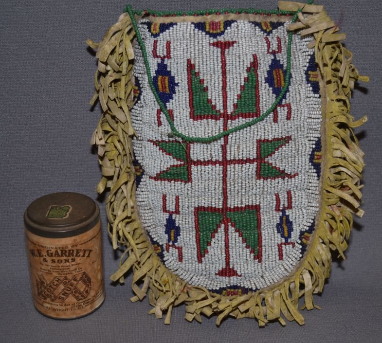 SIOUX BEADED BAG: 1900 1910 fully beaded front geometric design with W.E. Garrett snuff can inside 7"x5.5" Shipping charge are for the continental United States only There will be additional shipping fees on shipments 