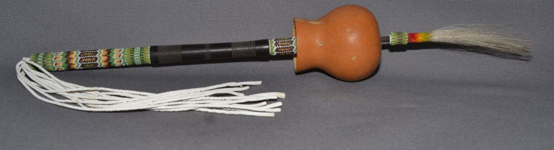 PLAINS PEYOTE RATTLE: 1980's gourd style with beaded handle, 23'' long Shipping charge are for the continental United States only There will be additional shipping fees on shipments to Hawaii, Alaska and outside the United