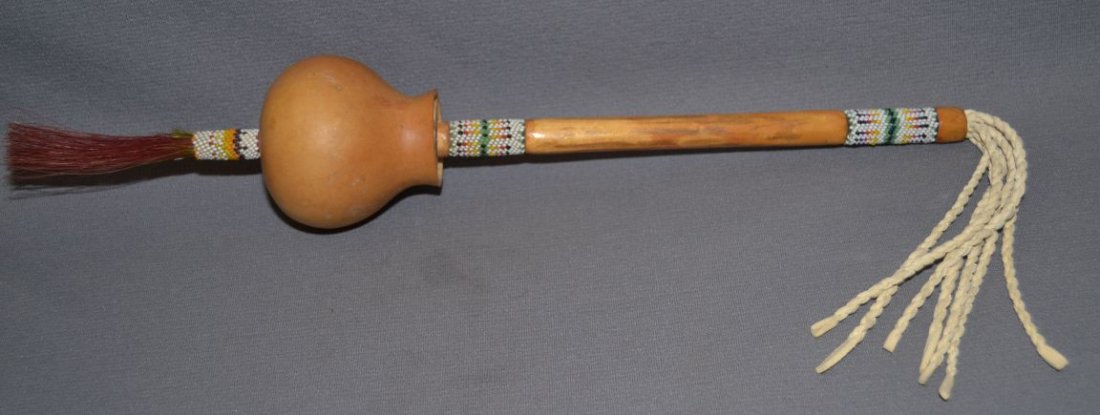 PLAINS PEYOTE RATTLE: 1980's gourd style with beaded handle, 20'' long Shipping charge are for the continental United States only There will be additional shipping fees on shipments to Hawaii, Alaska and outside the United