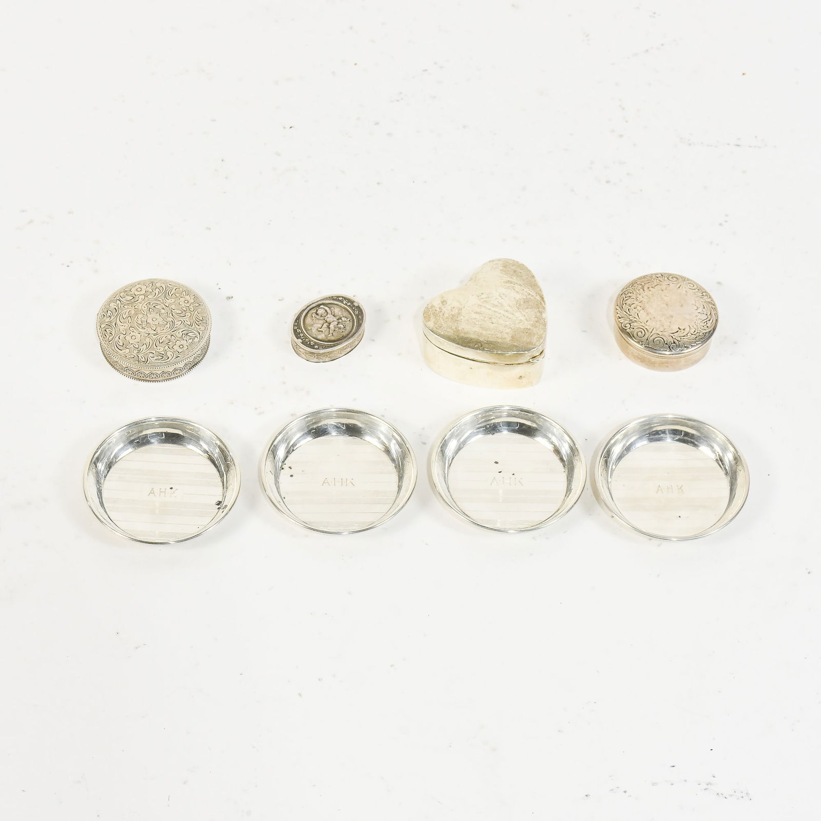 Group of Silver and Silver Plated Table Articles: Comprising four pill boxes and a set of four coasters * (Largest 2 3/4" dia) Some dings and dents