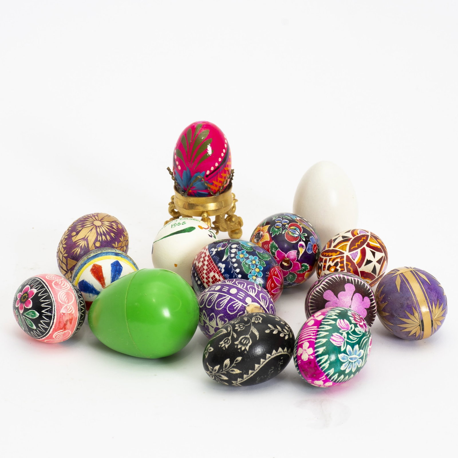 Group of Fifteen Painted Eggs: Together with brass egg holder with dolphin supports * AS IS