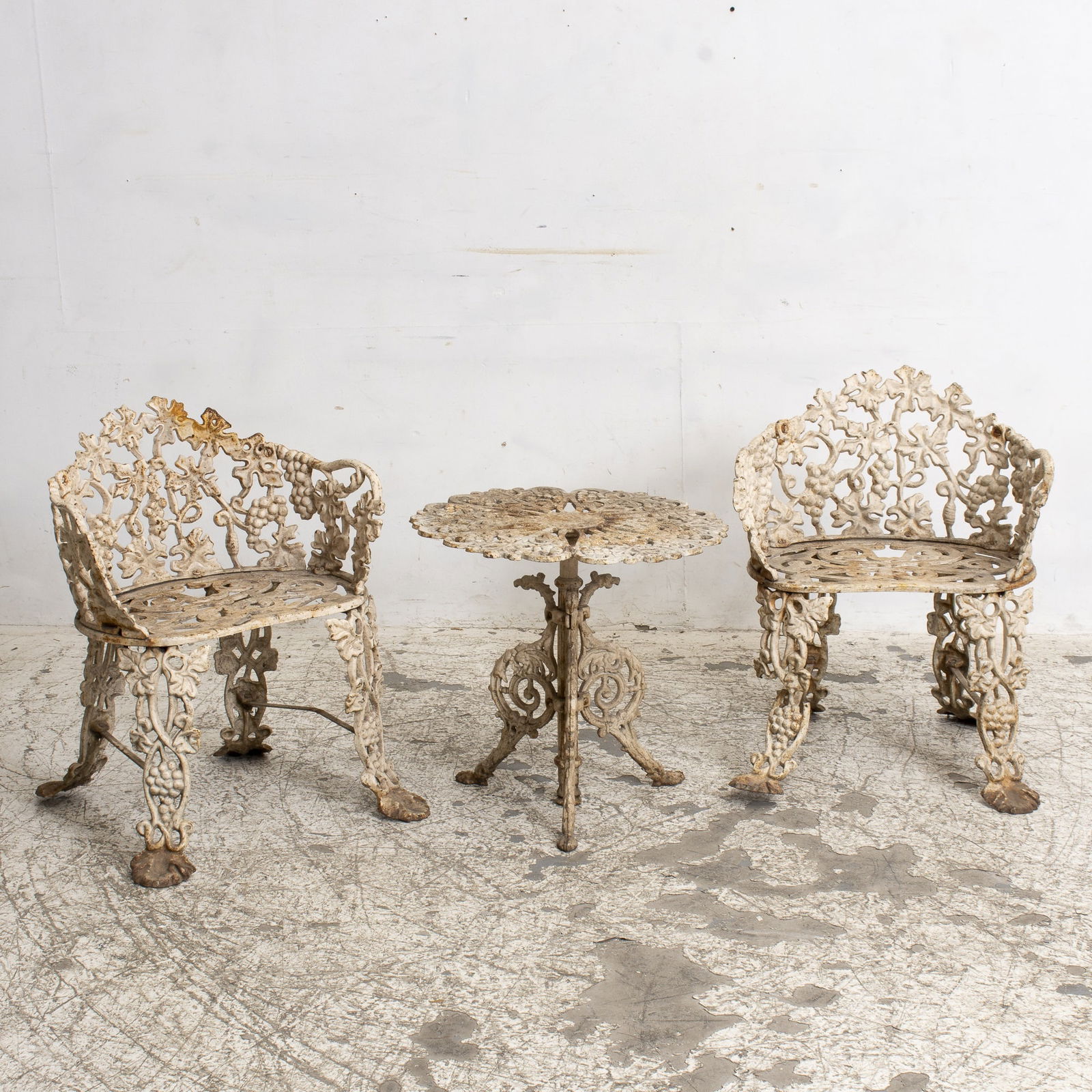 Group of White Painted Wrought Iron Garden Furniture: Comprising table, pair of chairs * (Table 19" h x 20" dia Chairs 26" h x 18" w x 12" d) overall wear