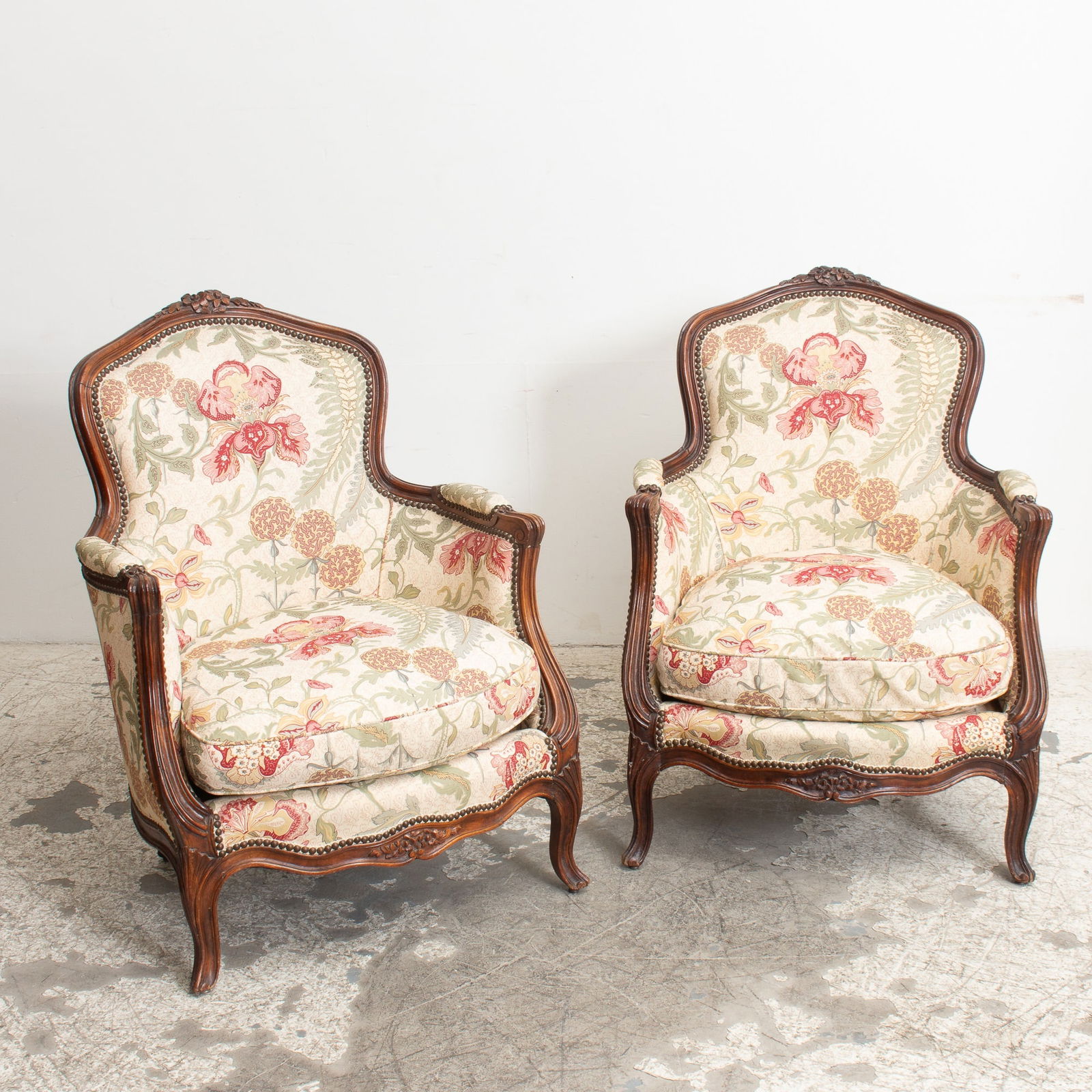 Pair of Louis XV Style Bergeres: With floral upholstery (36 1/2" h x 27" w x 23" d Seat to floor 13" h) Scratches and chips to wood