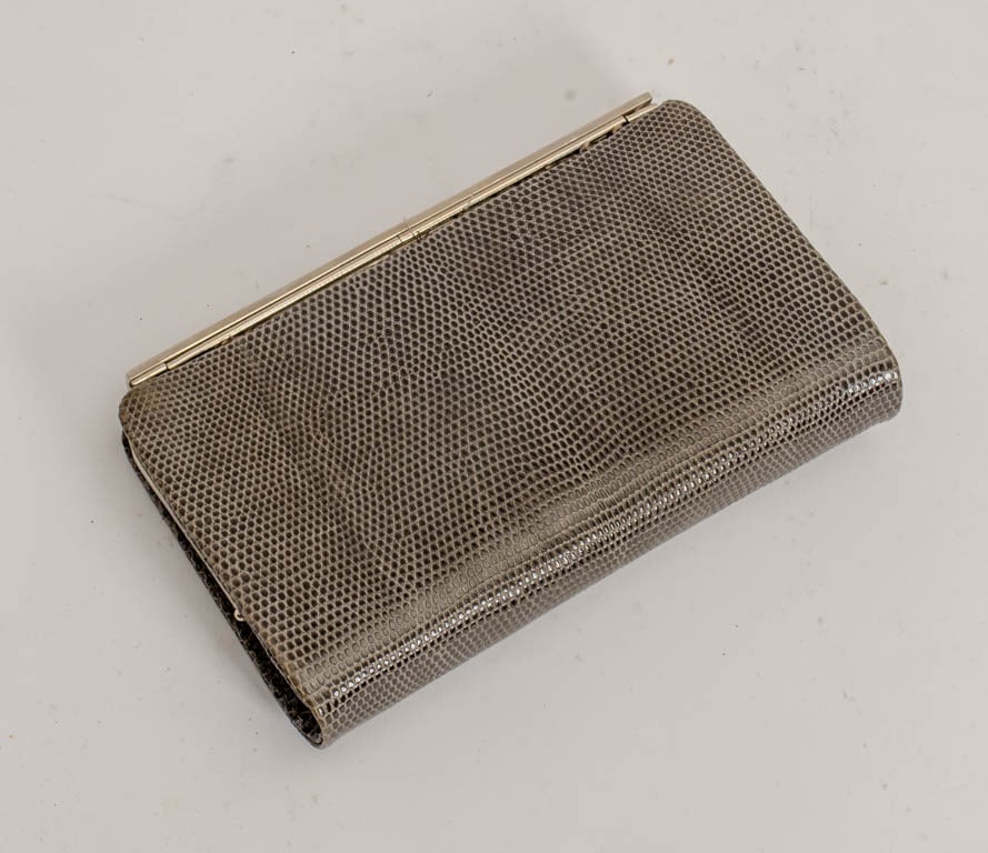 Gucci Grey Snakeskin Clutch: Grey snakeskin with silver-tone hardware and double 'GG' front closure, grey leather interior, signed Gucci. (4 1/2" h x 7" w x 1 5/8" d) Moderate wear