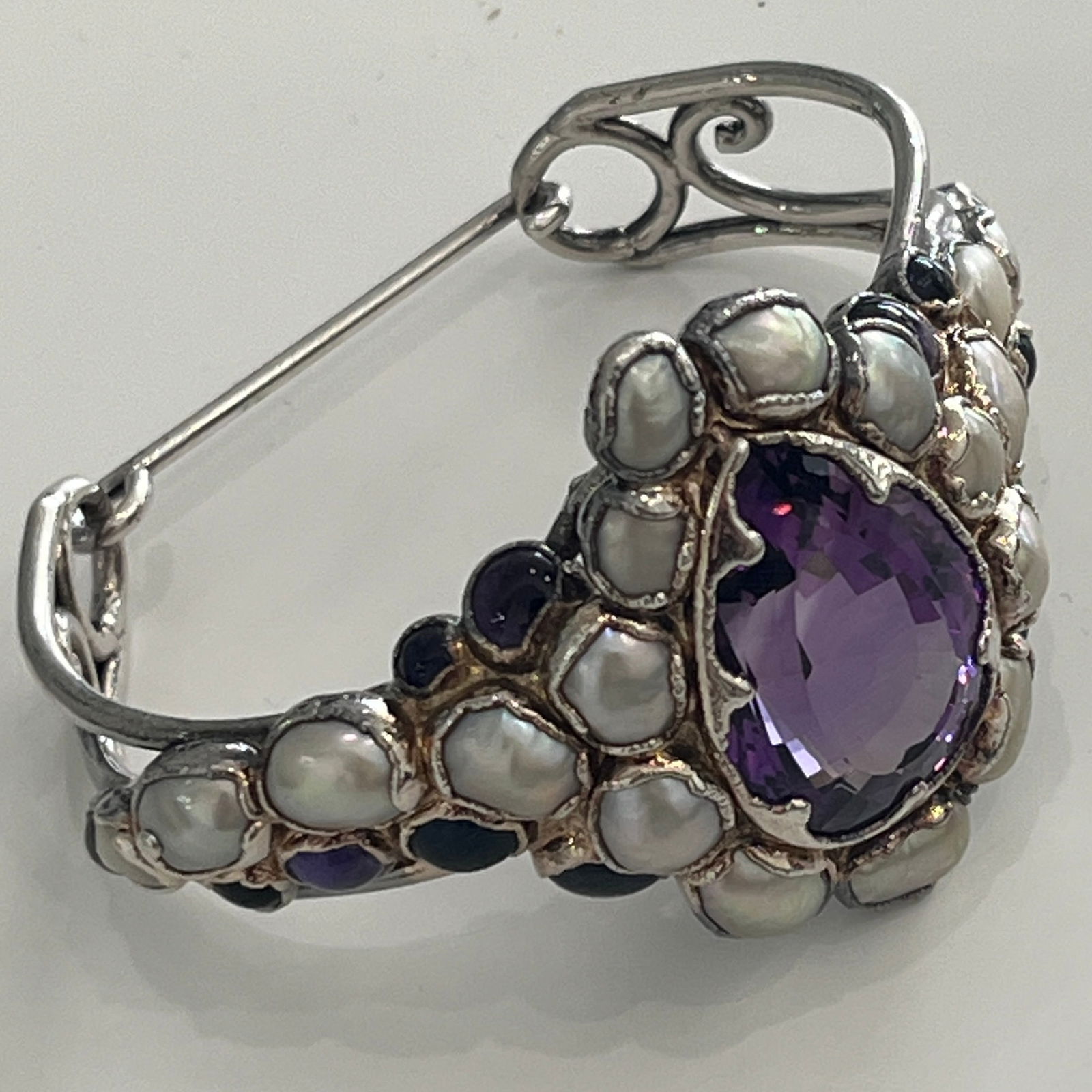 Silver, Amethyst, Cabochon Amethyst, Blister Pearl, and Moonstone Cuff Bracelet: One pear-shaped amethyst ap. 37.00 cts., 12 oval and round cabochon amethysts, 18 pearls ap. 9.0 to 5.0 mm., 2 round moonstones, ap. 30.4 dwts * (Inner circumfrence 7") Amethyst: medium to