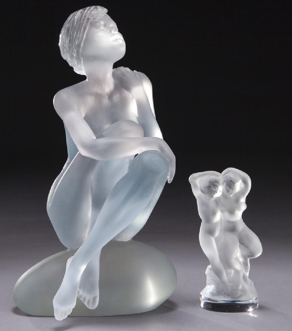 Daum Deville-Chabrolle crystal figure: Daum Deville-Chabrolle crystal figure depicting Aphrodite seated on a rock. Signed to base, "Deville Chabrolle Daum France 67/475" together with (1) Lalique frosted crystal figure depicting nude male 
