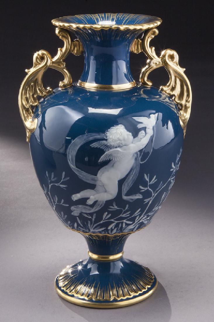 Minton pate-sur-pate decorated vase: Minton pate-sur-pate decorated vase with two scrolling gilt handles, decorated with cupid holding a dove, with trophy of doves, basket and flowers on reverse, gilt and impressed marks. PROVENANCE: Fro