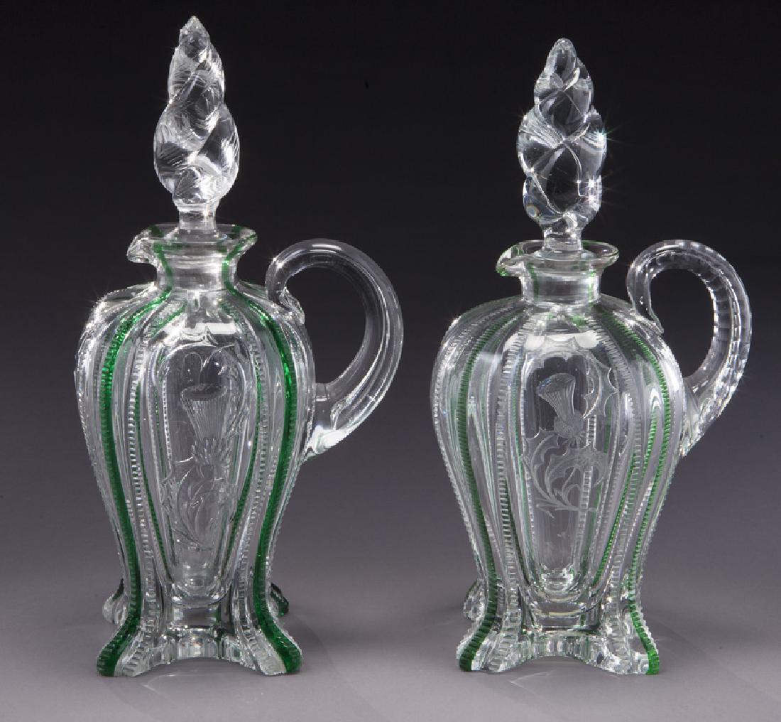 (2) Stevens & Williams cut glass ewers: (2) Stevens & Williams cut glass ewers with clear and green zipper, adorned with central thistle. Marked, "S&W Fleur de Lis". 10"H, Circa - 1890. PROVENANCE: From the Estate of John W. Lolley, Monroe,