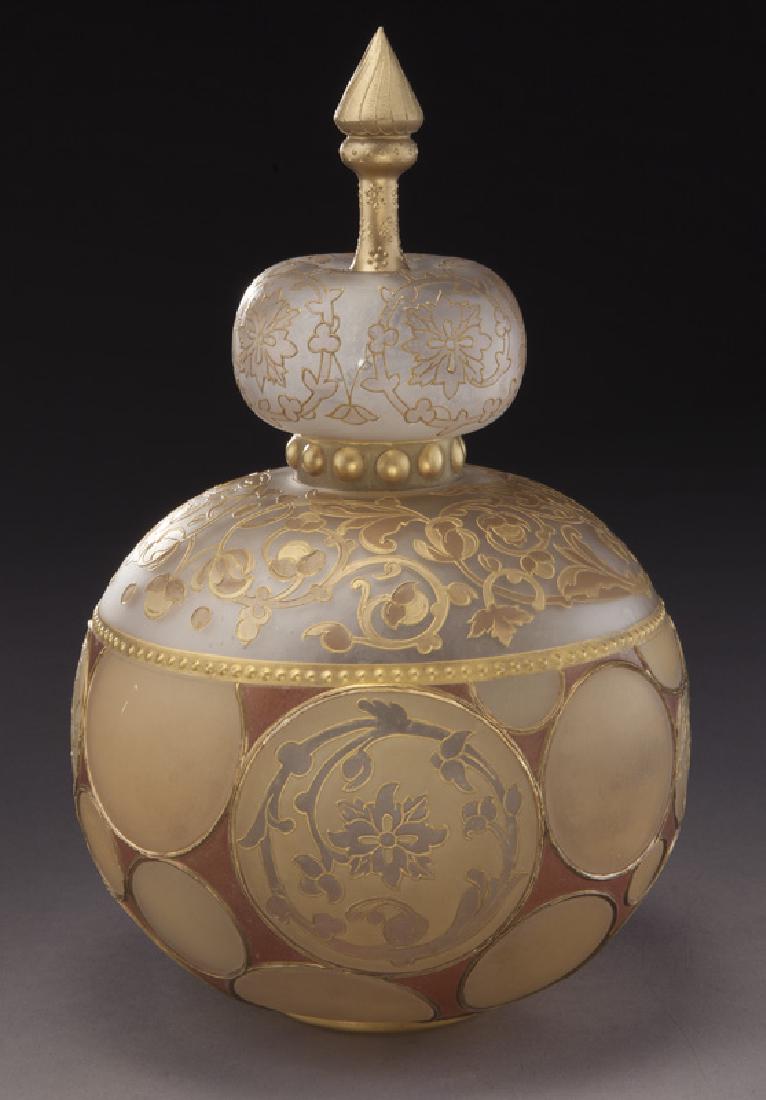 Mt. Washington Royal Flemish covered jar,: Mt. Washington Royal Flemish covered jar, globular form with circular medallions adorned with scrolling collar and fitted with a crown finial lid. NOTE: Mt. Washington & Pairpoint Glass by Wilson, pag