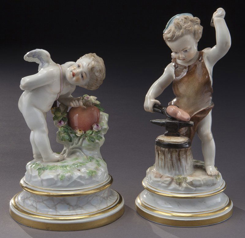 (2) Meissen porcelain figures of cupid,: (2) Meissen porcelain figures of cupid, (1) Cupid Forging Heart, Incised "L114"; (1) Cupid Knocking on Heart, Incised "L121". Each raised on a faux marble base and bearing crossed swords mark in blue
