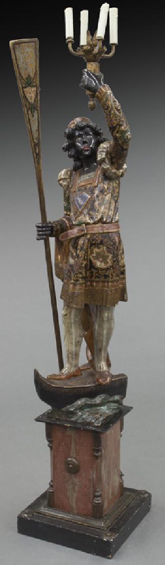 Venetian polychrome blackamoor,: Venetian polychrome blackamoor, one arm holding an oar and the other raising a 4-light torch, atop a boat-form base above square pedestal. 67.5"H x 14"W, Circa - 19th C.