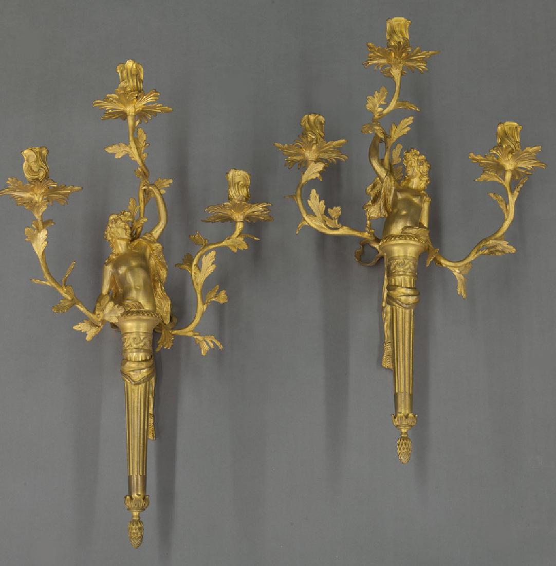 Pr. French dore bronze 3-light figural sconces,: Pr. French dore bronze 3-light figural sconces, the tapered fluted standard surmounted by male and female classical nude issuing vine-form arms ending in scrolling bobeches. 22"H x 13"W x 9"D, Circa -