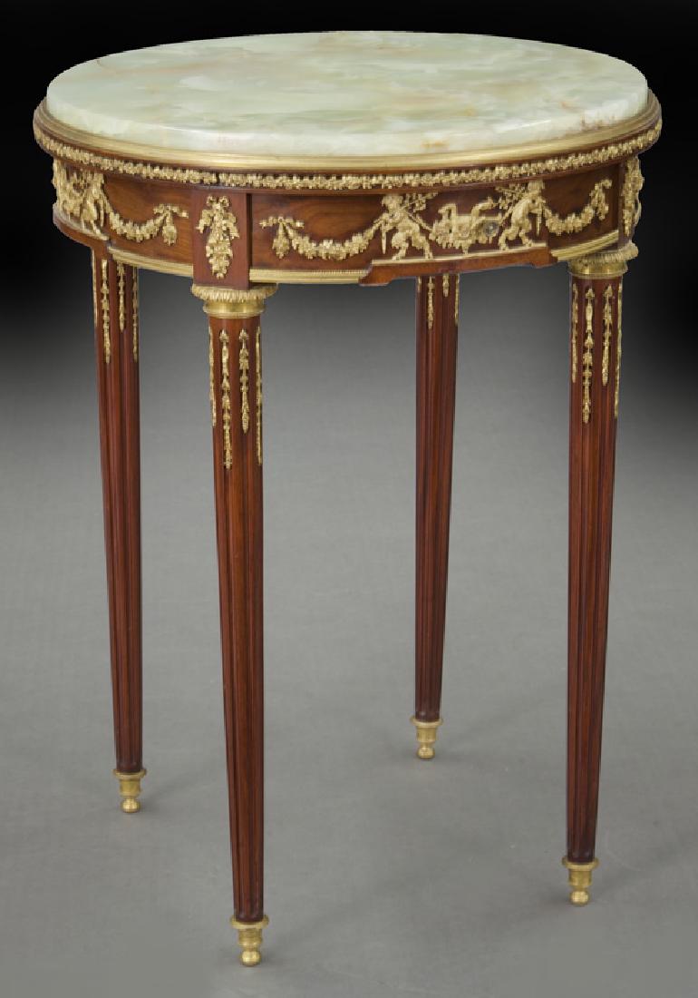 Francois Linke gueridon, index num. 200: Francois Linke gueridon, index num. 200 in mahogany with green onyx top and one frieze drawer, the entire frieze decorated with gilt bronze figures and garlands, tapered fluted legs with ormolu mounts
