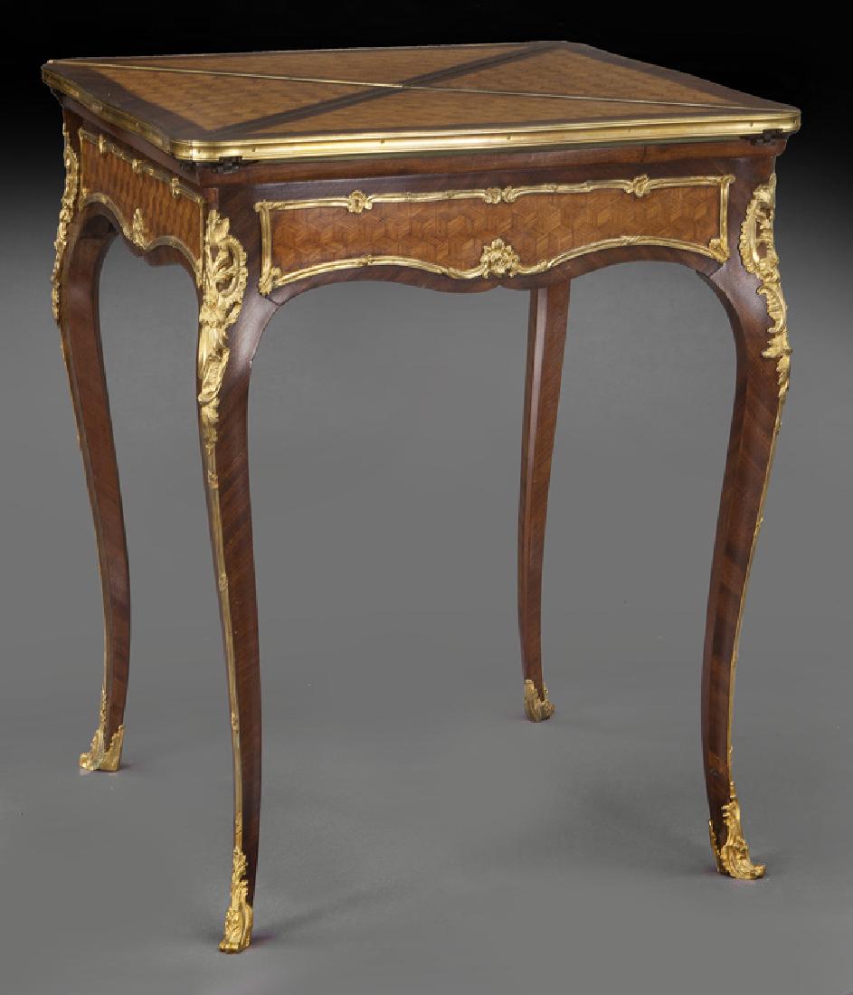 Francois Linke mahogany and kingwood envelope: Francois Linke mahogany and kingwood envelope table with gilt bronze mounts, in the Louis XV style. The top turning and opening into a baise lined game table. Linke signature to bronze mount. 29.25"H