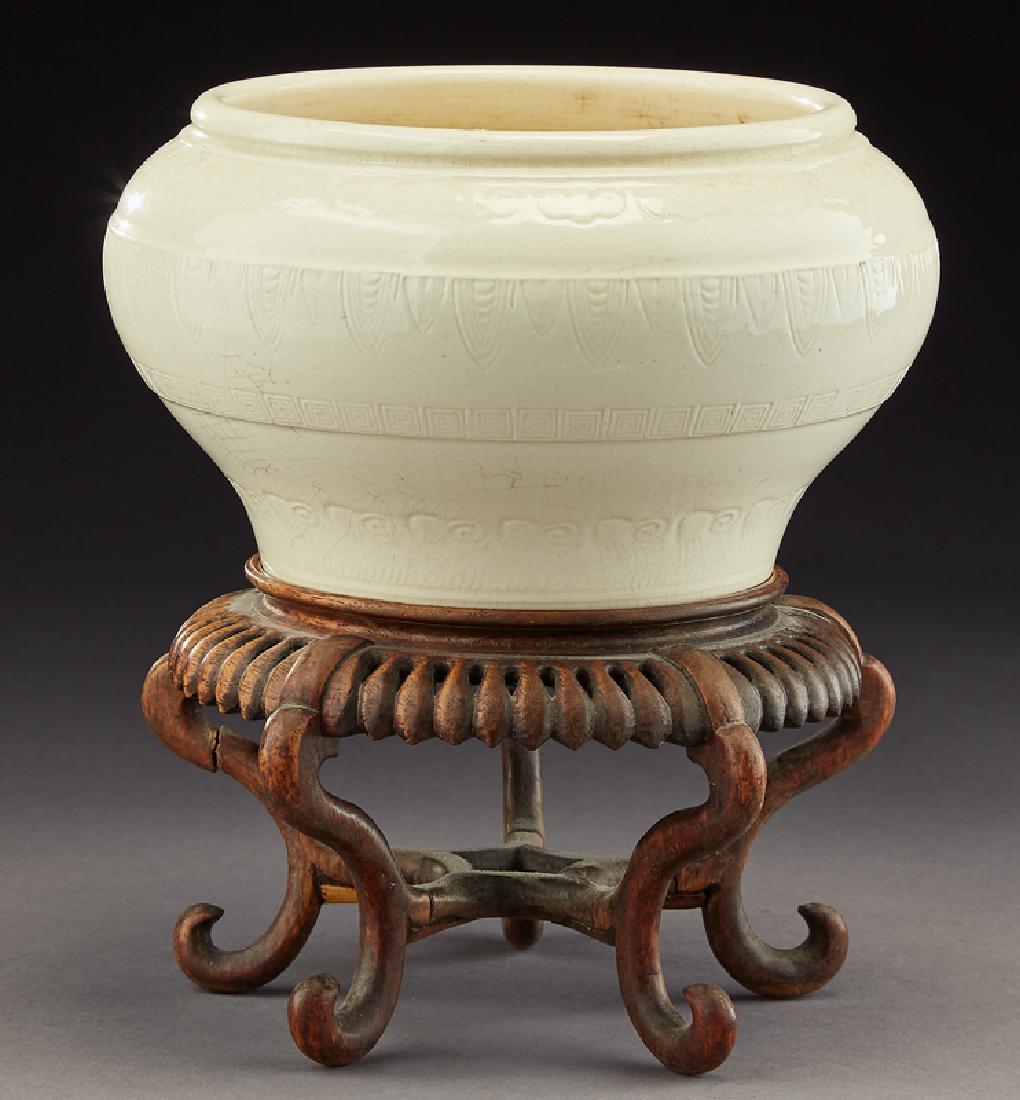 Chinese Qing blanc de chine vase,: Chinese Qing blanc de chine vase, modeled to depict cicado and Linzhi symbols, raised on a hardwood stand. 5.125"H x 8.875"W, Circa - 19th C. PROVENANCE: Estate of Ms. Louise Moorrees (maiden name). H