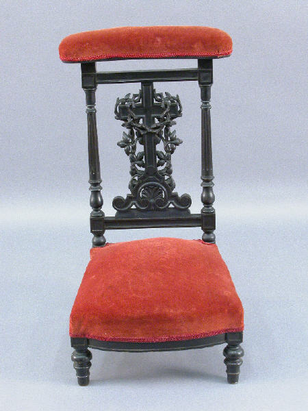 French Prie Dieu w/ carved foliate draped: cross, fluted columns and a shell motif with an ebonized finish. Prie Dieu upholstered in velvet. Restoration to small section of carving on back. 35"H x 19.25"W x 20"D, Circa - Last half of the 1800'