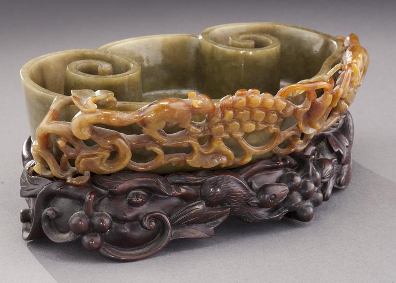 Chinese Qing carved jadeite brush washer: Chinese Qing carved jadeite brush washer depicting squirrels and grapes, raised on a rosewood stand. 1.625"H x 7"W x 1.5"D, Circa - 19th C.