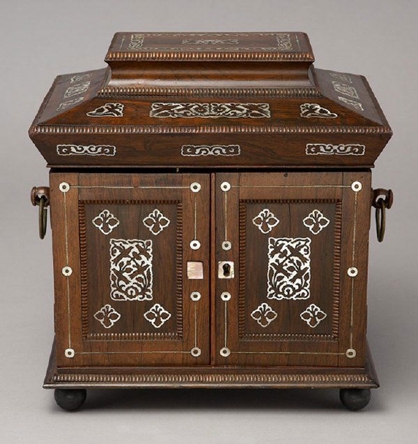 Rosewood and mother-of-pearl inlay jewelry box: having three drawers, one containing a small lap desk, two doors, the interior fitted with hand tooled leather panels, and a hinged lid, in a sarcophagus shaped case. 13.5"H x 13.25"W x 10"D, Circa -
