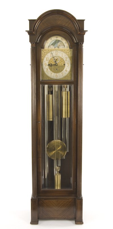 Colonial Mfg. Co. 5-tube tall case clock: the arched top case with full reeded columns and beveled glass door. The three weight movement having moon phase dial with applied brass filigree work and striking on five tubes. Movement stamped on b
