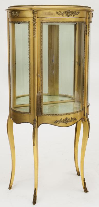 Louis XV style display cabinet,: the rounded glass front and sides raised on cabriole legs, gilt mounts throughout. Circa - 20th C.