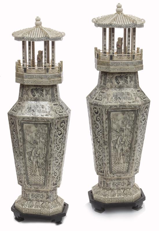 Asian style bone clad urns,: the lid featuring a pagoda with central figure over base with carved dragon to reserve surrounded by etched floral and scrolling design. Raised on black lacquer bases. Without base: 38.5"H,