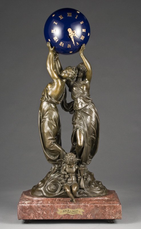 French Louis XV style clock, "Jour et Nuit" par: Claudius, modeled as two maidens holding aloft a blue orb enclosing the clock movement, a cherub at their feet holding an hour glass and a garland, the bronze signed, "aug moreau". 28"H x 13"W x 7"D, 