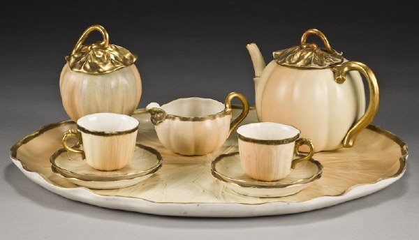 10 Pc. Royal Worcester porcelain tea set: consisting of a large leaf pattern oval tray, teapot, creamer, sugar, (2) cups and (4) saucers with gilt borders, handles and lids. Tray : 19.25"H x 15.75"W, Circa - 1892.