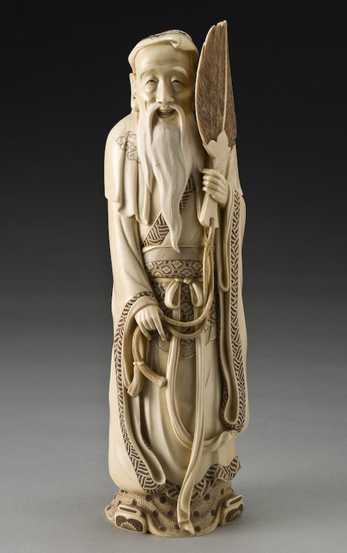 Japanese Meiji carved ivory immortal holding a fan: Japanese Meiji carved ivory immortal holding a fan (International shipping IS NOT available on this item. This elephant ivory was imported legally into the United States.) in his left hand, wearing a 