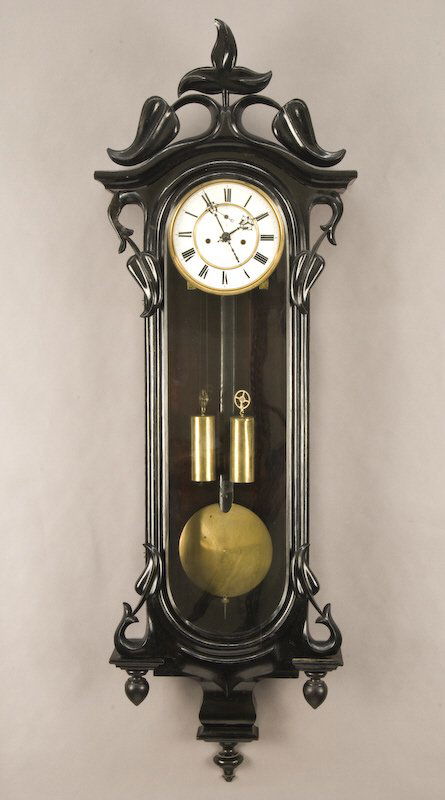 Vienna regulator 2-weight wall clock, ebonized: case, porcelain dial with subsidiary seconds dial, brass movement striking on a coiled gong. Movement marked, "Genossensch Germania Freiburgi/Schles 55808". 46.5"H x 14.25"W x 5"D, Circa - 1870.