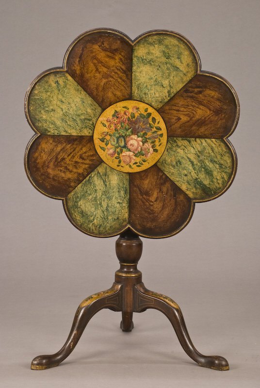 Unusual 8-lobed tilt top table, the top with: alternating hand grained panels centered by a circular panel of painted flowers, on a baluster and urn form column supported by a tripod cabriole leg base ending in slipper feet with painted decoratio