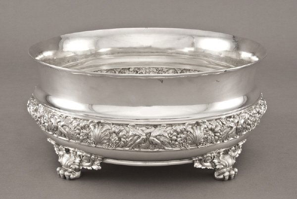 Tiffany sterling silver center bowl,: the rolled edge with a scrolled underside, the body with a repousse band modeled to depict, shells, flowers and nautical masks; the whole supported by four winged paw feet. Marked, "Tiffany and Co 747