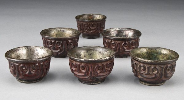 (6) Chinese Yuan - Ming dynasty Tixi cinnabar: libation cups depicting the face of the beast, having silver interiors. Provenance: Important Texas Collection. 1.5"H x 2.5" Dia., Circa - 13th - 14th C.