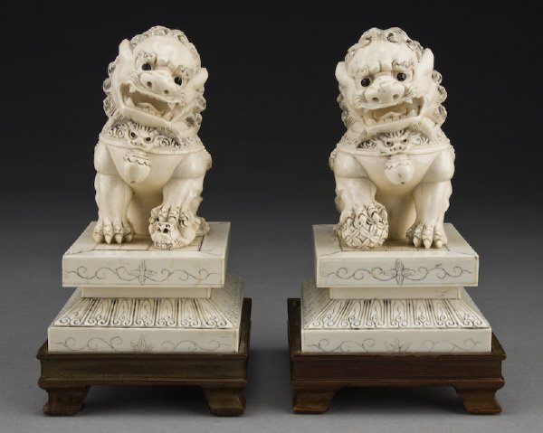 Pr. Ivory foo dogs raised on hardwood stands.: (International shipping IS NOT available on this item. This elephant ivory was imported legally into the United States.) Without stand: 6"H, Circa - 20th C.