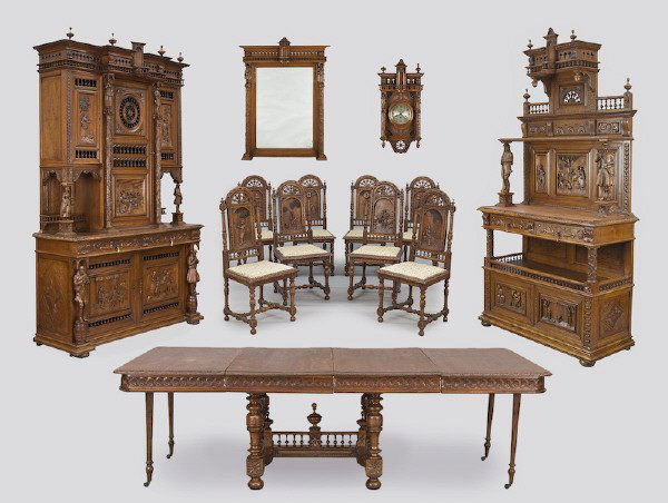 13 Pc. Brittany figural carved oak dining room set: consisting of a large cupboard on cupboard (108"H x 66"W x 23.5"D), server (95"H x 51"W x 19.5"D), extending dining table (49.5"L x 45.5"W, plus two 23.25" leaves), set of (8) chairs (43.5"H x 18.75"W