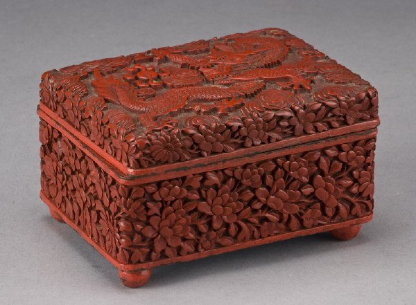 Chinese Qing carved cinnabar box depicting dragons: and peonies. 3"H x 3.5"W x 5"D, Circa - 19th C.