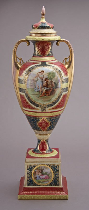 Monumental Royal Vienna style porcelain lidded urn: having alternating panels of maroon, yellow and green, surrounded with gilt accents, the central reserve depicting a sleeping soldier and his muse, signed, "Kaufmann". Repairs. 35"H x 9" Square at bas